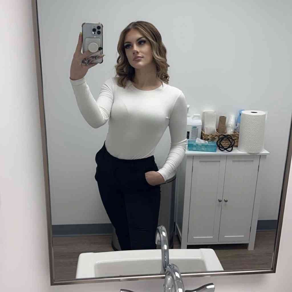 Victoria Anne Cranmer taking a mirror selfie with her phone.